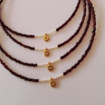 Καφέ κολιέ με πέρλες και επιχρυσωμένο στοιχείο ήλιο στο κέντρο