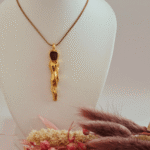 Επιχρυσωμένο κολιέ σε λιτή γραμμή με σμάλτο καφέ που θυμίζει αφαιρετική ανθρώπινη φιγούρα