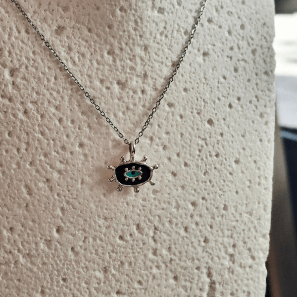 Kολιέ με μαύρη βάση και τιρκουάζ λεπτομέρεια, εμπνευσμένο από το σύμβολο του ματιού